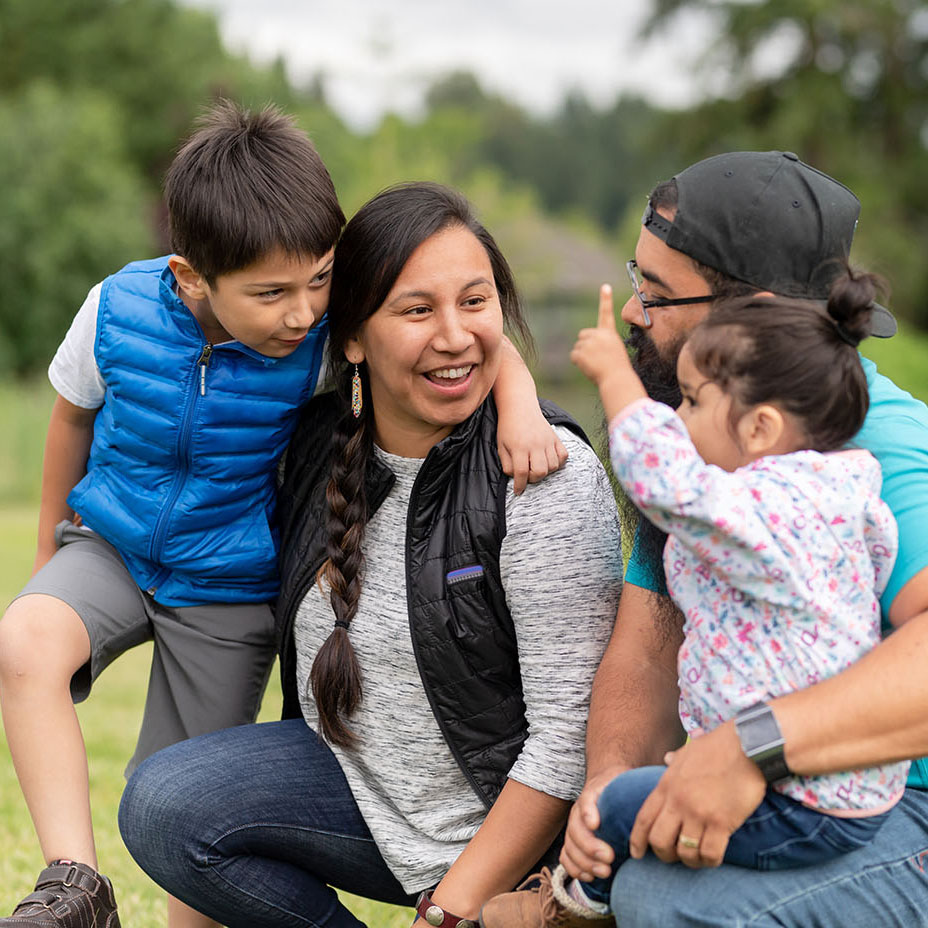 Parents with two young children outdoors.